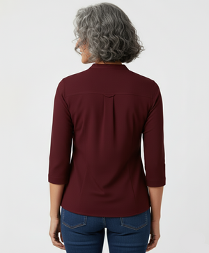 Person wearing a burgundy long-sleeve shirt on a white background