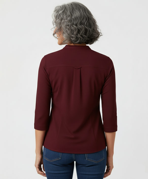 Person wearing a burgundy long-sleeve shirt on a white background