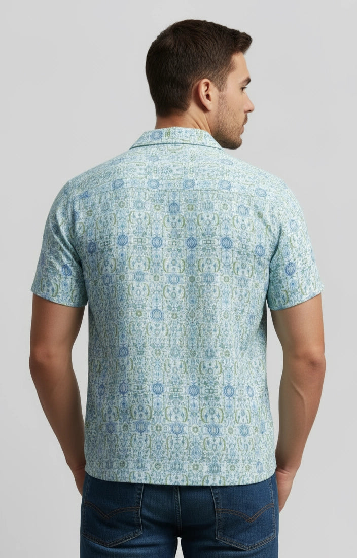 Man wearing a light blue patterned shirt on a gray background