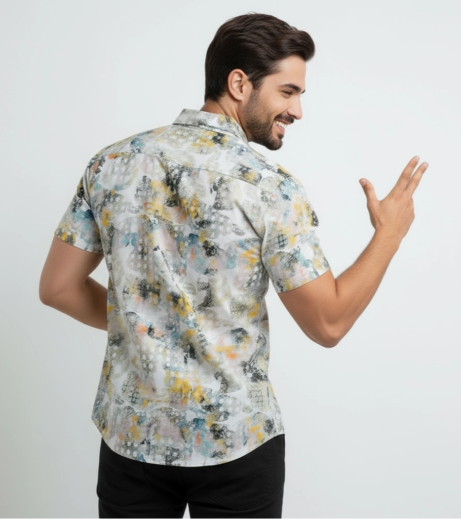 Man wearing a short-sleeve, patterned shirt on a plain background