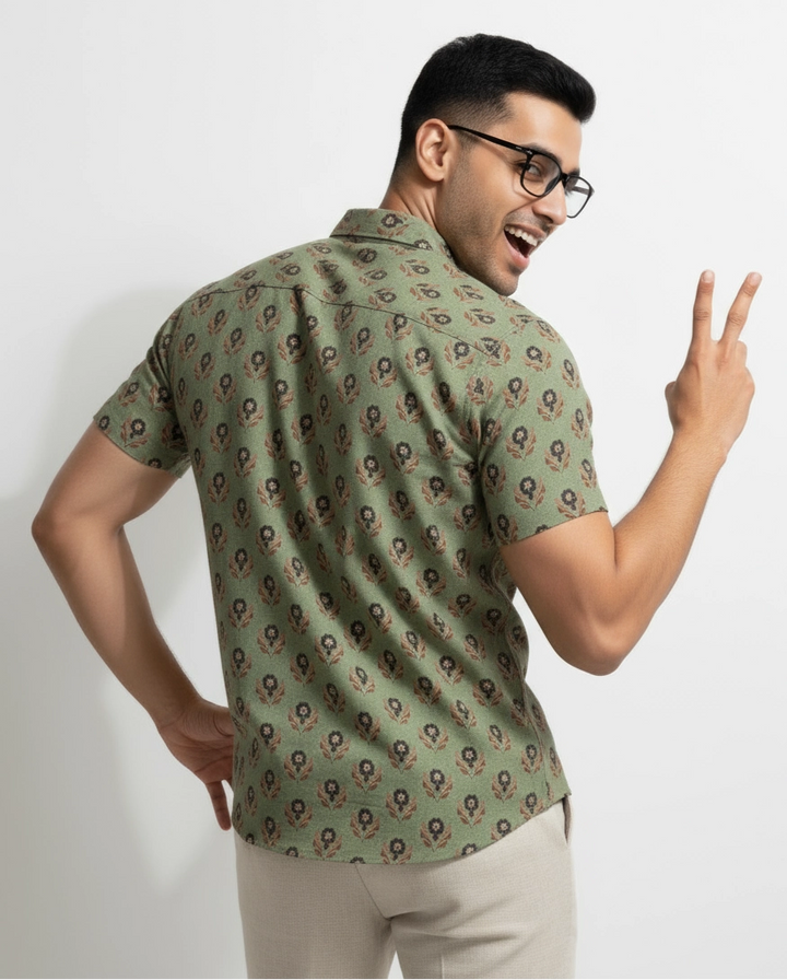 Man wearing a light Green olive pista color floral and geometric patterned men shirt. short sleeve, spread regular collar